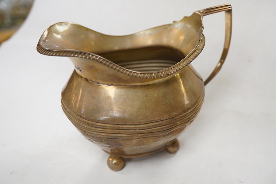 A late Victorian silver oval teapot, William Hutton & Sons, London, 1899, together with a George III silver cream jug, London, 1811, gross weight 15.4oz.